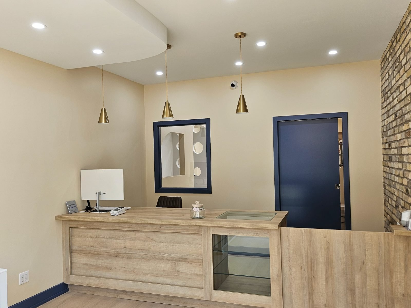 Reception desk inside Rumi Grooming Studio with warm wood and pendant lighting